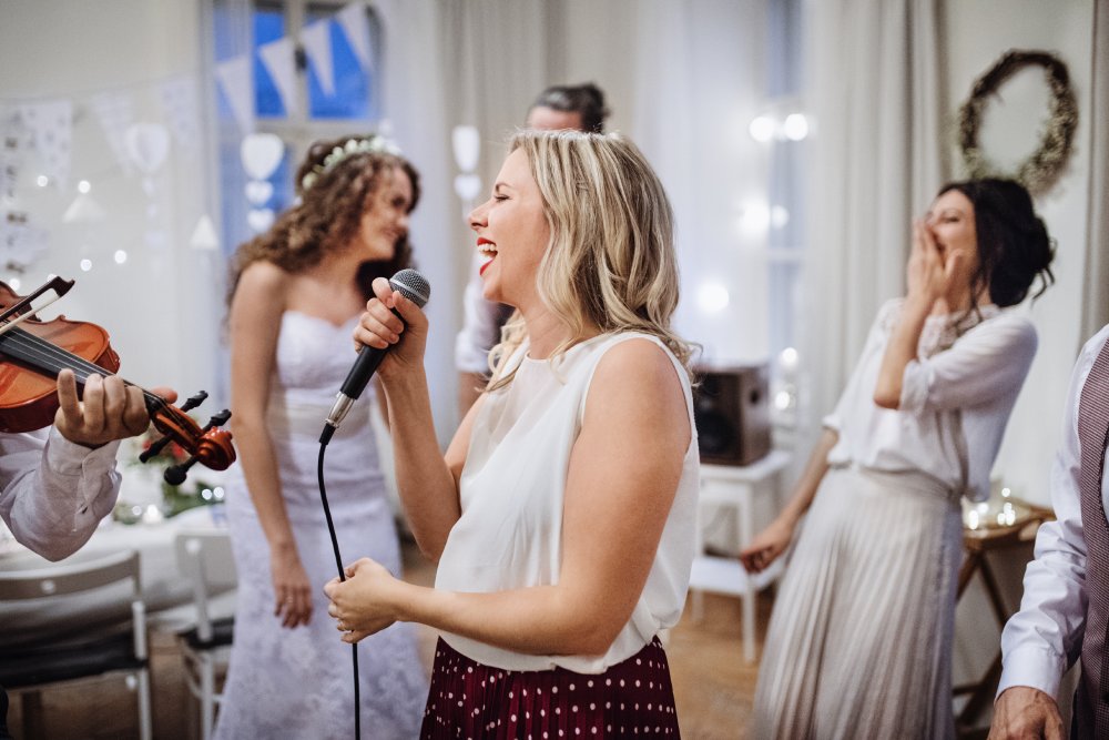 a-young-woman-singing-on-a-wedding-reception-brid-2021-08-26-12-09-29-utc.jpg
